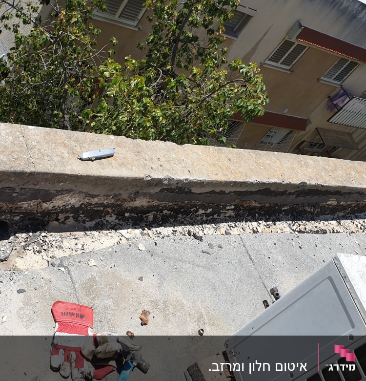 כפפות וכלי עבודה על גג עם איטום ישן